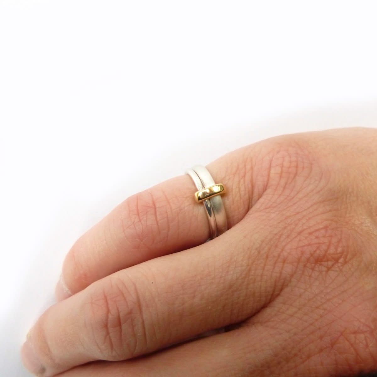 Handmade silver and 18ct gold double‑band ring worn on hand, showing the contemporary mixed‑metal design.