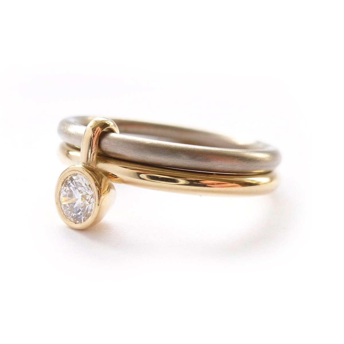 A unique modern contemporary 18ct gold two tone stacking engagement ring with white diamond. Multi band ring or interlocking ring, sometimes called double band ring too.