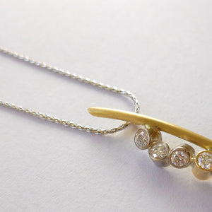 A modern two tone gold and diamond necklace / pendant with a soft necklet